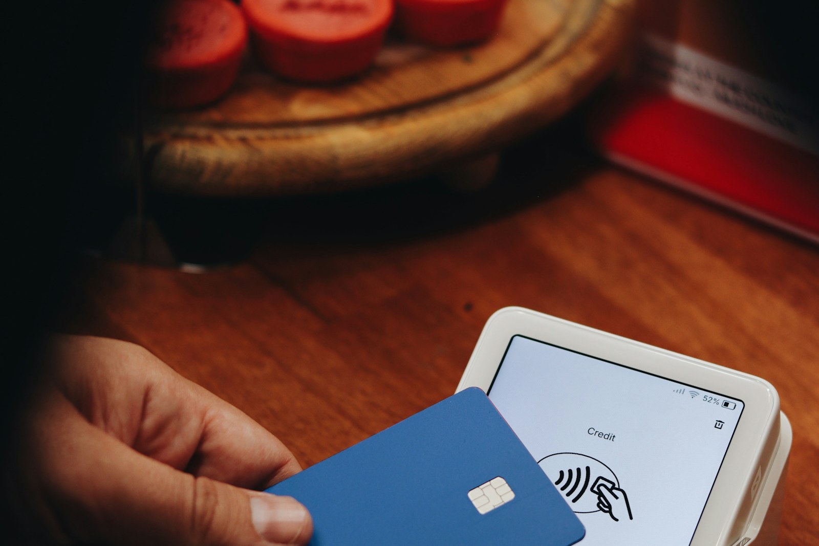 A customer holding a payment card to check out at a store